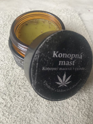 Domáca konopná masť s CBD z odrody Finola v tmavej sklenenej dóze s včelím voskom.